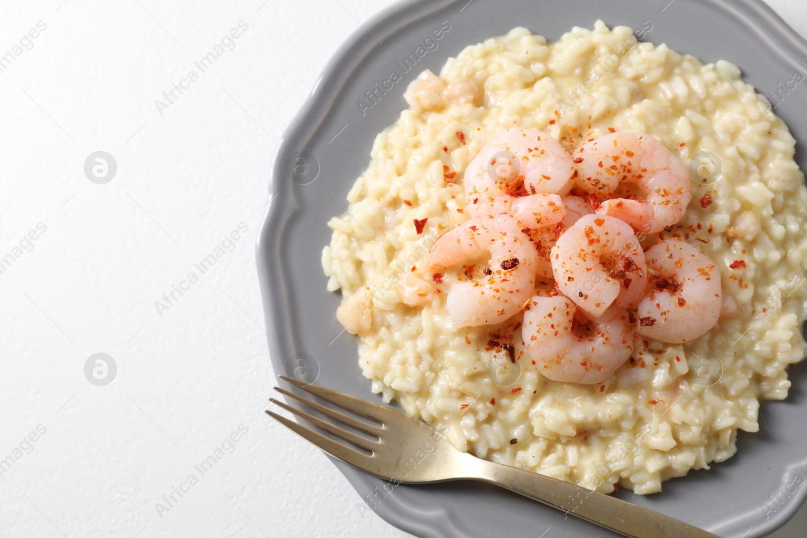 Photo of Delicious risotto with shrimps and cheese on white table, top view