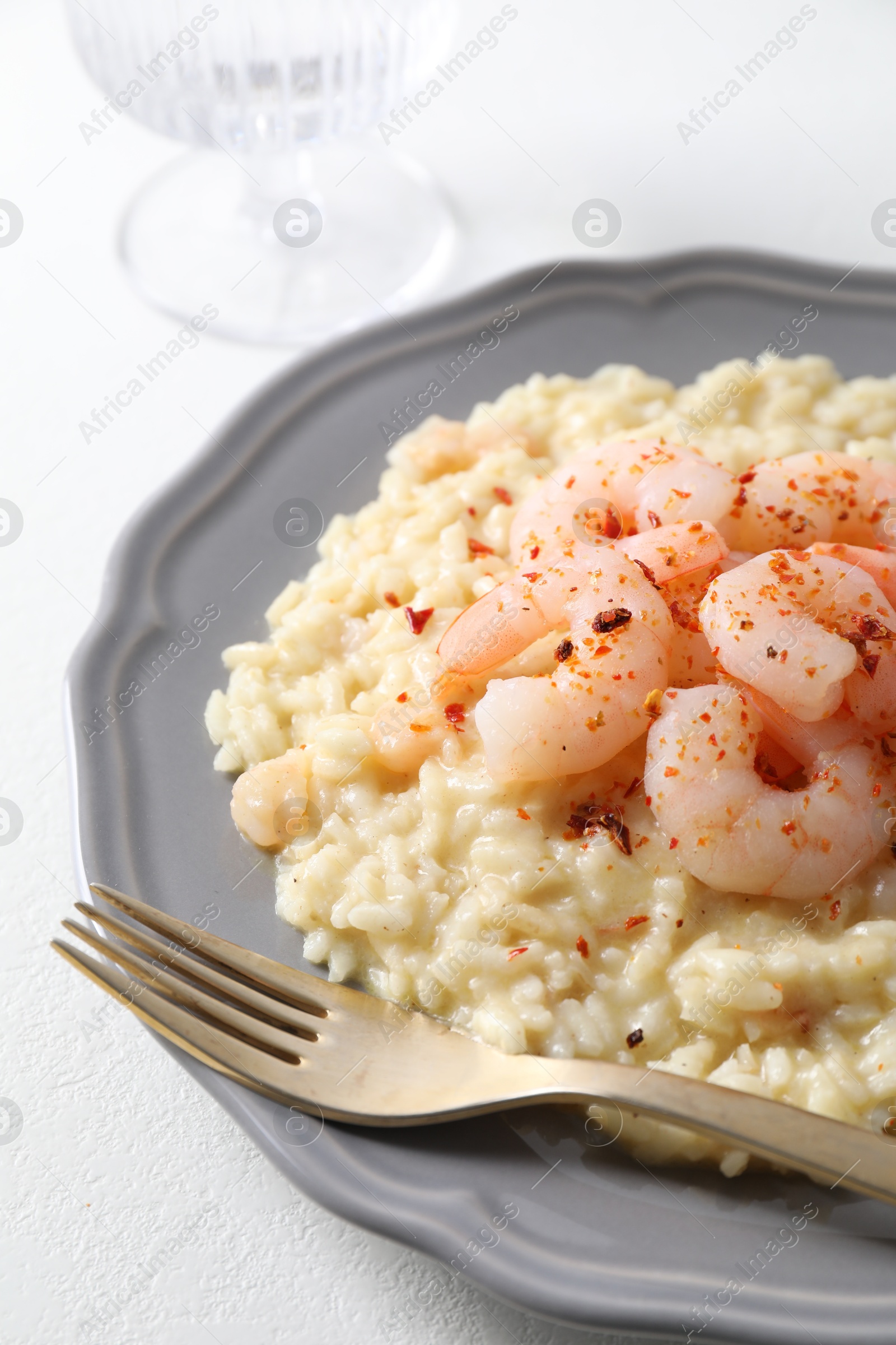 Photo of Delicious risotto with shrimps and cheese on white table, closeup