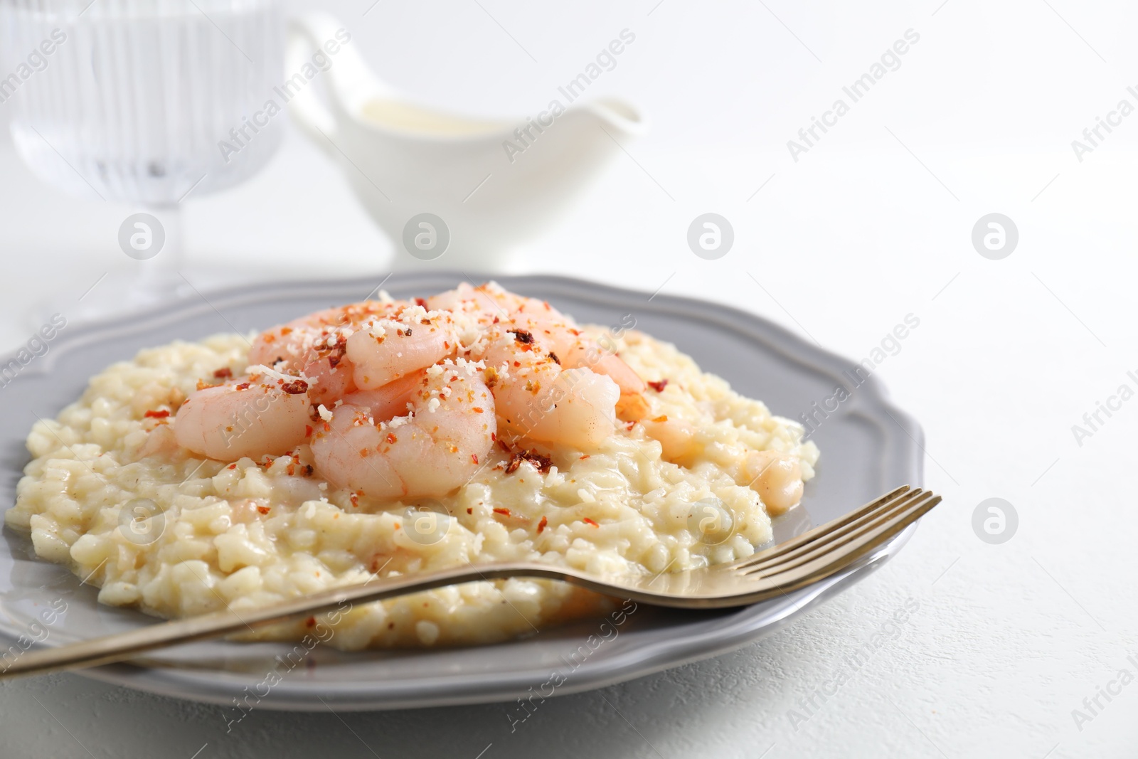 Photo of Delicious risotto with shrimps and cheese on white table, closeup