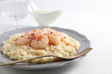 Photo of Delicious risotto with shrimps and cheese on white table, closeup