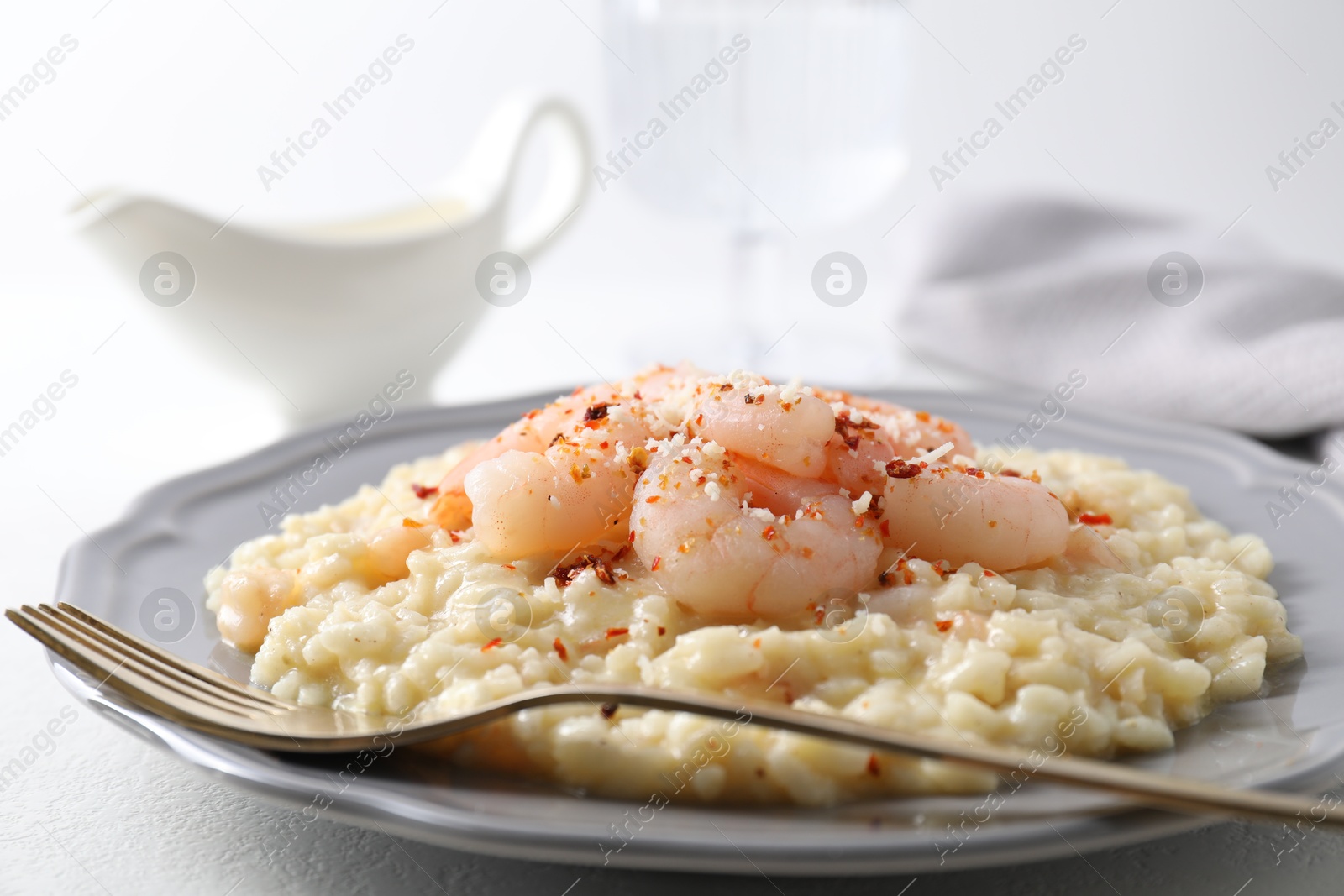 Photo of Delicious risotto with shrimps and cheese on white table, closeup