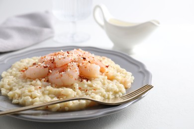 Photo of Delicious risotto with shrimps and cheese on white table, closeup