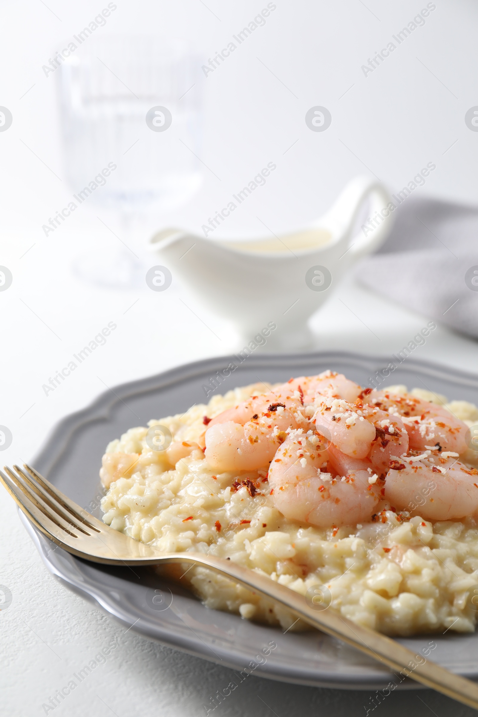 Photo of Delicious risotto with shrimps and cheese on white table, closeup