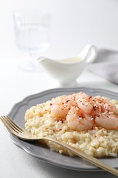 Photo of Delicious risotto with shrimps and cheese on white table, closeup