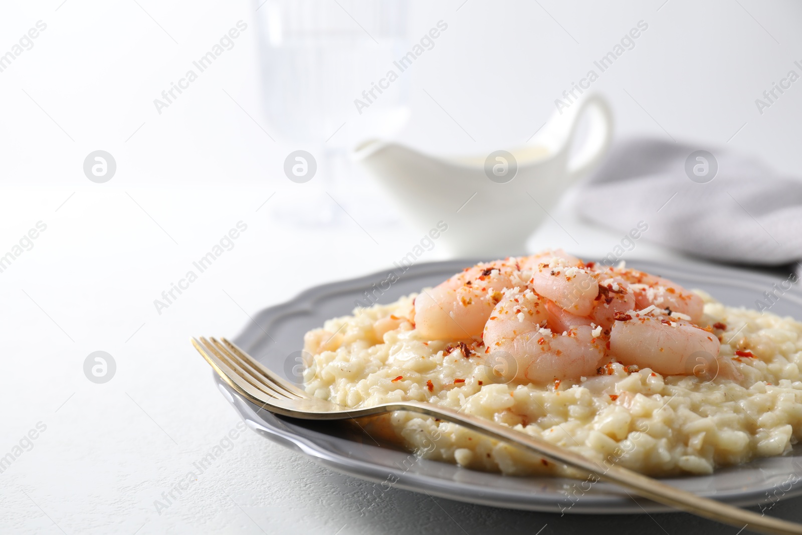 Photo of Delicious risotto with shrimps and cheese on white table, closeup