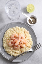 Photo of Delicious risotto with shrimps and cheese served on light grey table, top view