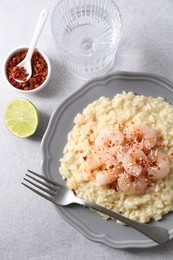 Photo of Delicious risotto with shrimps and cheese served on light grey table, top view