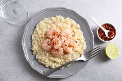 Photo of Delicious risotto with shrimps and cheese served on light grey table, top view