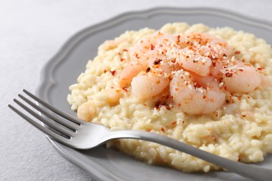 Photo of Delicious risotto with shrimps and cheese on light grey table, closeup