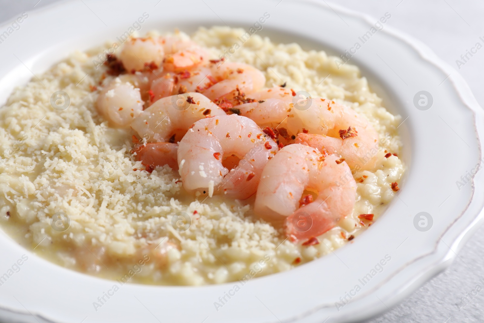 Photo of Delicious risotto with shrimps and cheese on table, closeup