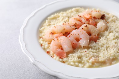 Photo of Delicious risotto with shrimps and cheese on light grey table, closeup