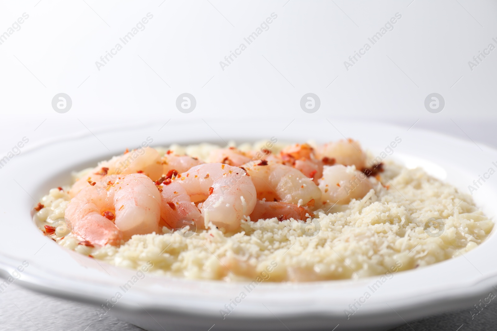 Photo of Delicious risotto with shrimps and cheese on table, closeup