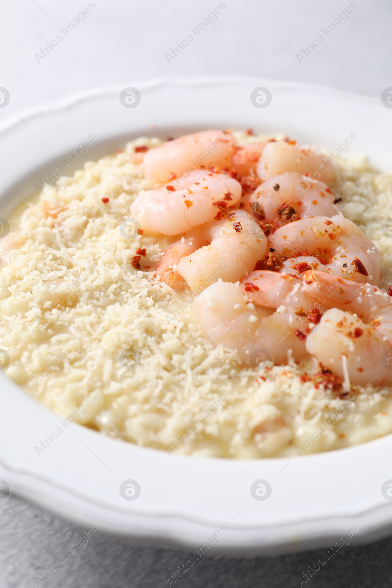 Photo of Delicious risotto with shrimps and cheese on table, closeup