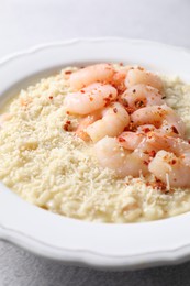 Photo of Delicious risotto with shrimps and cheese on table, closeup