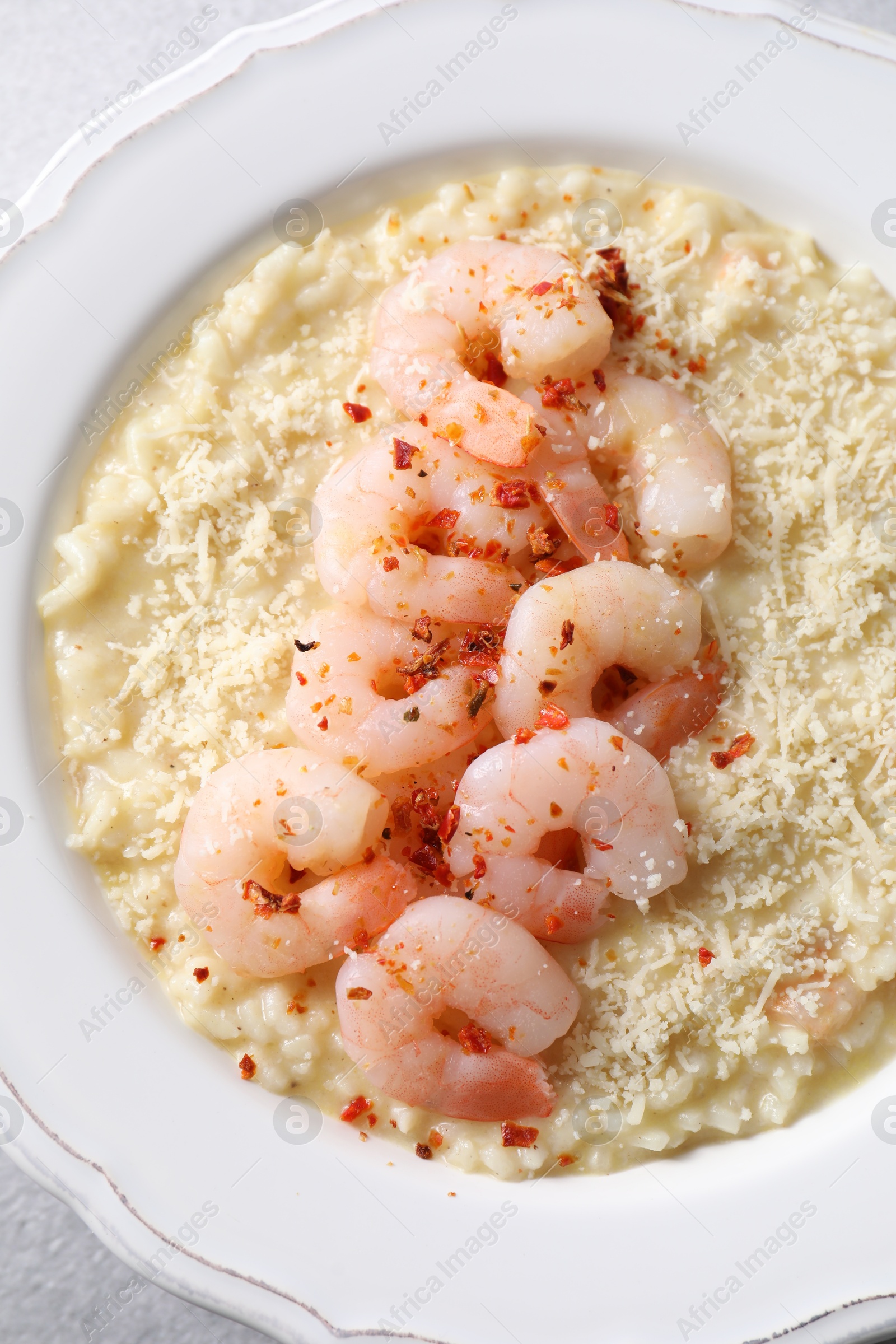 Photo of Delicious risotto with shrimps and cheese on table, top view