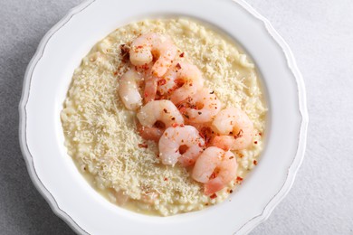 Photo of Delicious risotto with shrimps and cheese on light grey table, top view