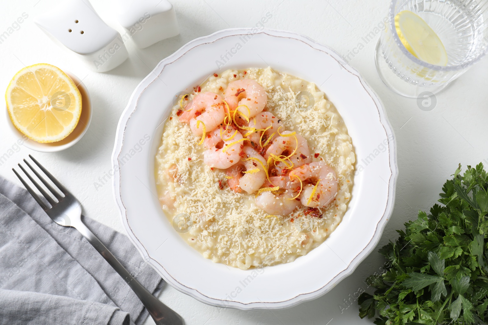 Photo of Delicious risotto with shrimps and cheese served on white table, top view