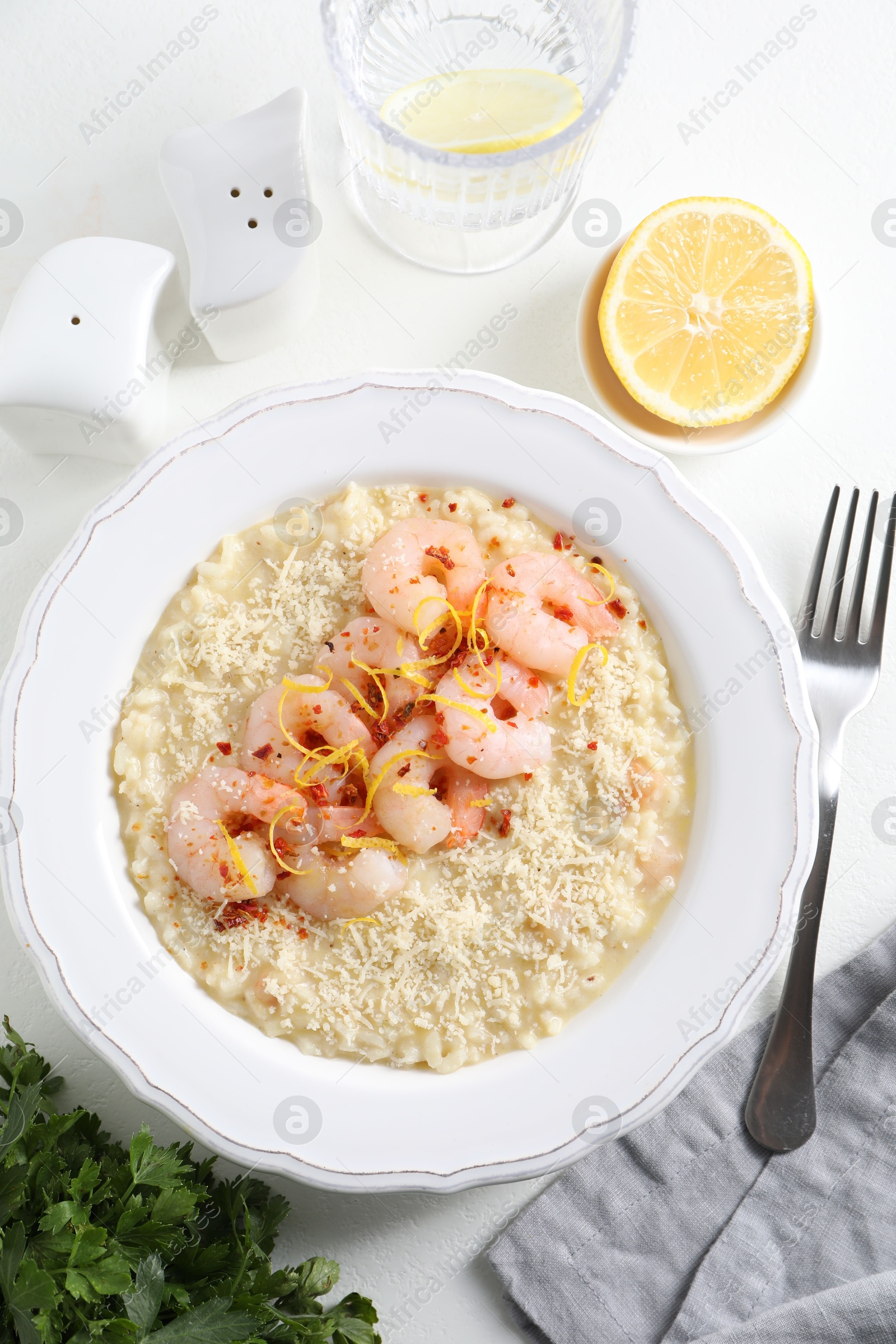 Photo of Delicious risotto with shrimps and cheese served on white table, top view