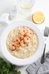 Photo of Delicious risotto with shrimps and cheese served on white table, top view