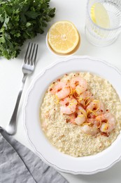 Photo of Delicious risotto with shrimps and cheese served on white table, top view