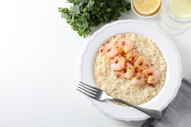 Photo of Delicious risotto with shrimps and cheese served on white table, top view. Space for text