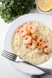 Delicious risotto with shrimps and cheese served on white table, top view