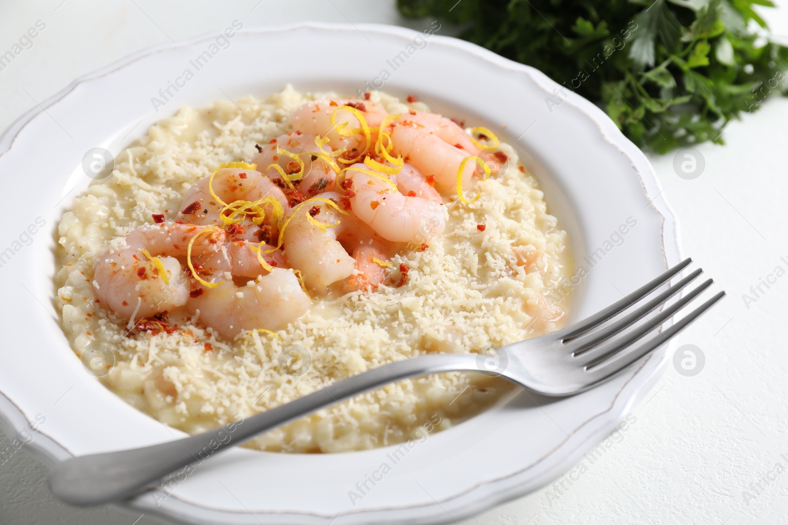 Photo of Delicious risotto with shrimps and cheese on white table, closeup