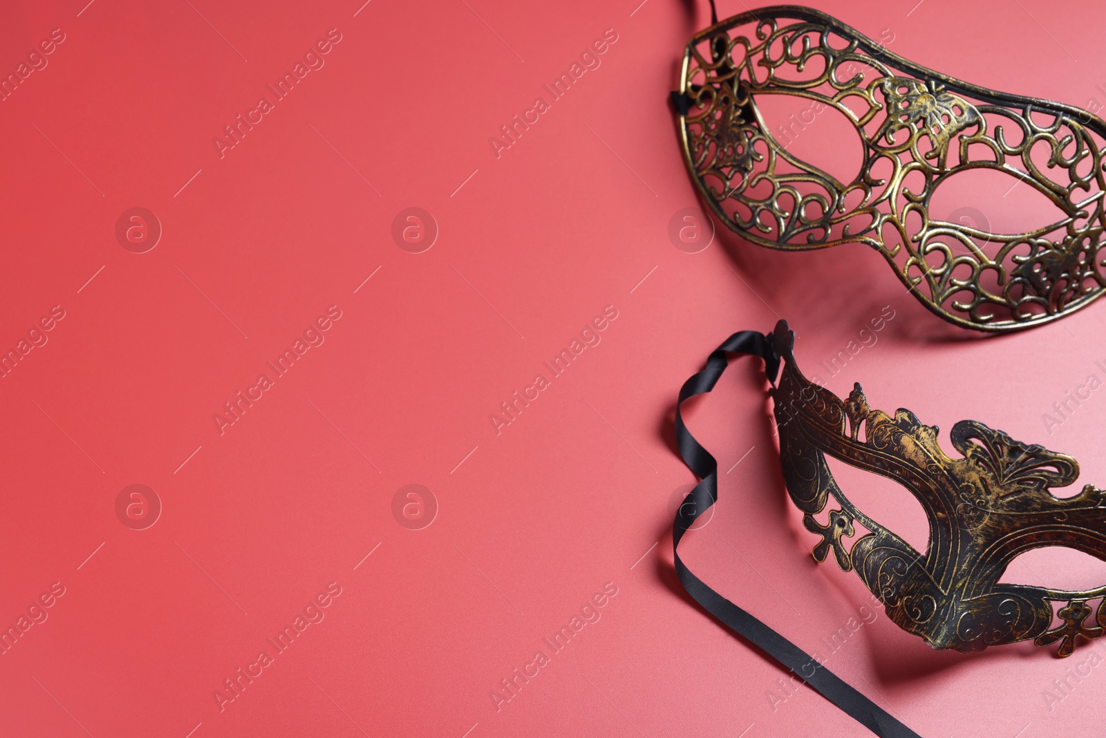 Photo of Beautiful carnival masks on red background, top view. Space for text