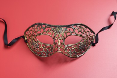 Photo of Beautiful carnival mask on red background, top view