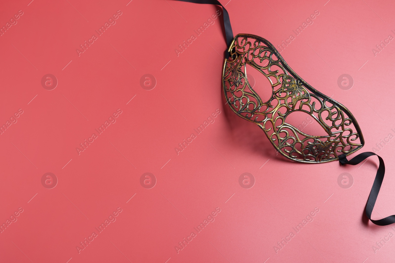 Photo of Beautiful carnival mask on red background, top view. Space for text