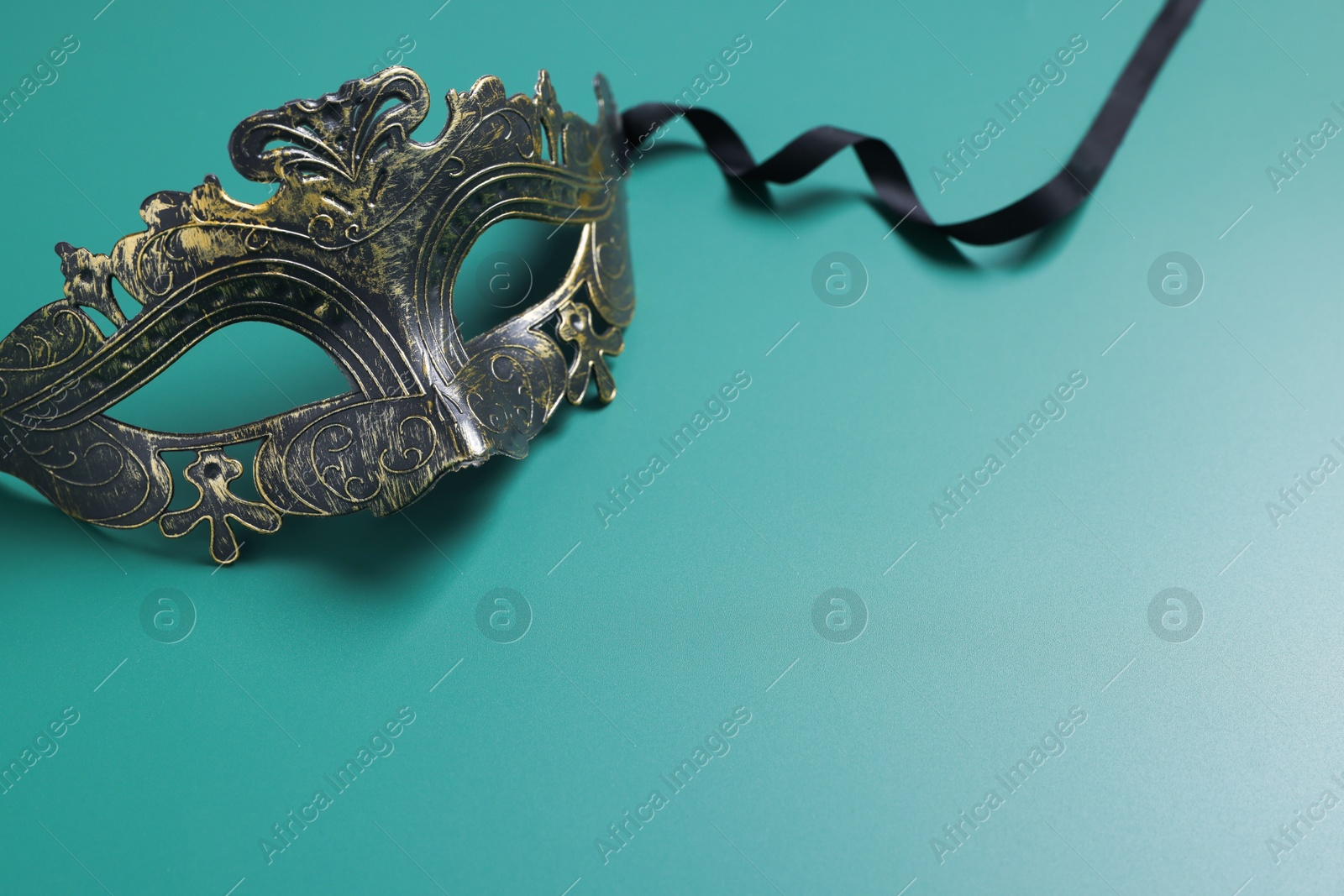 Photo of One beautiful carnival mask on teal background, space for text