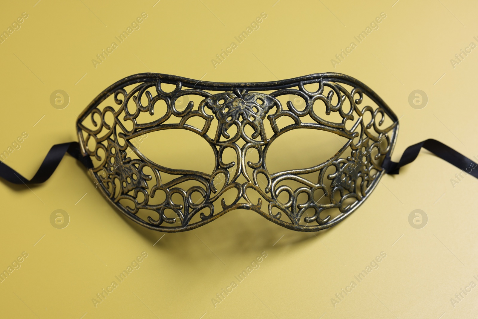 Photo of One beautiful carnival mask on yellow background