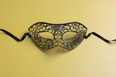 Photo of One beautiful carnival mask on yellow background