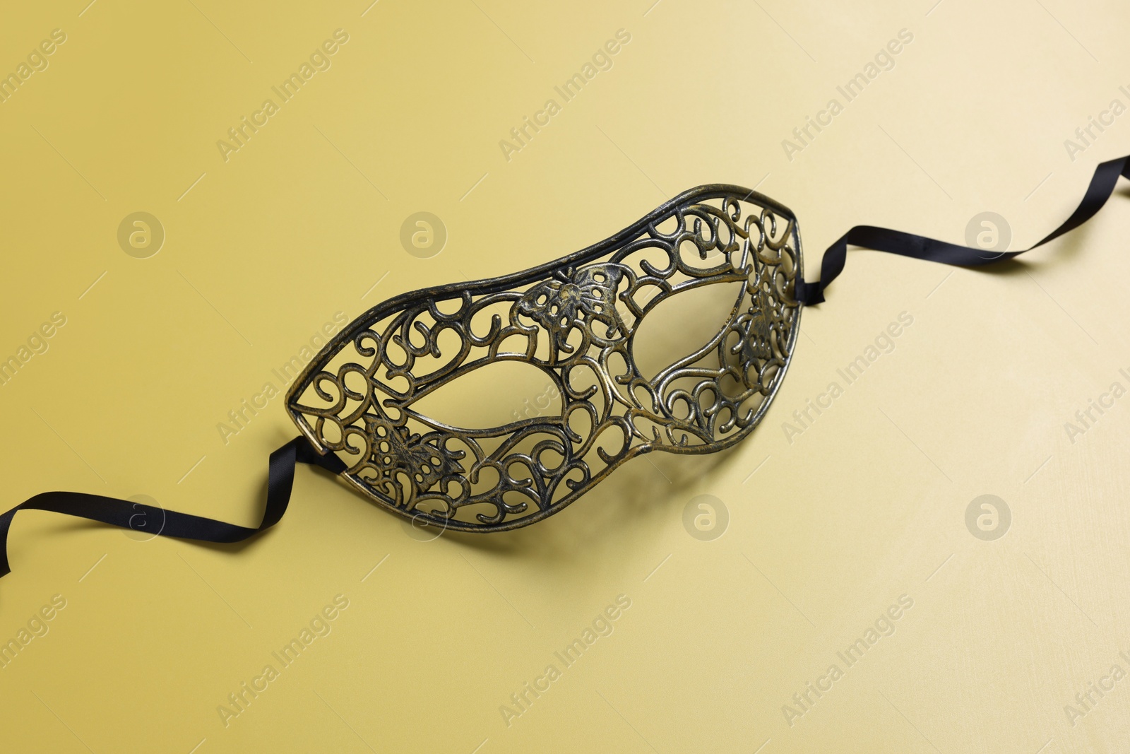 Photo of One beautiful carnival mask on yellow background