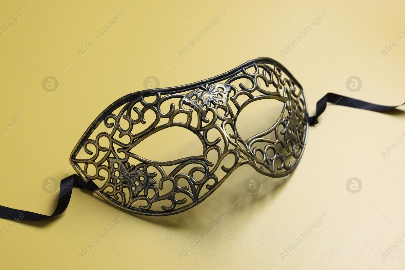 Photo of One beautiful carnival mask on yellow background