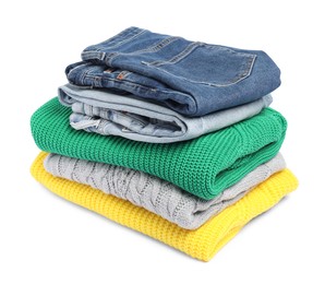 Photo of Stack of sweaters and jeans isolated on white