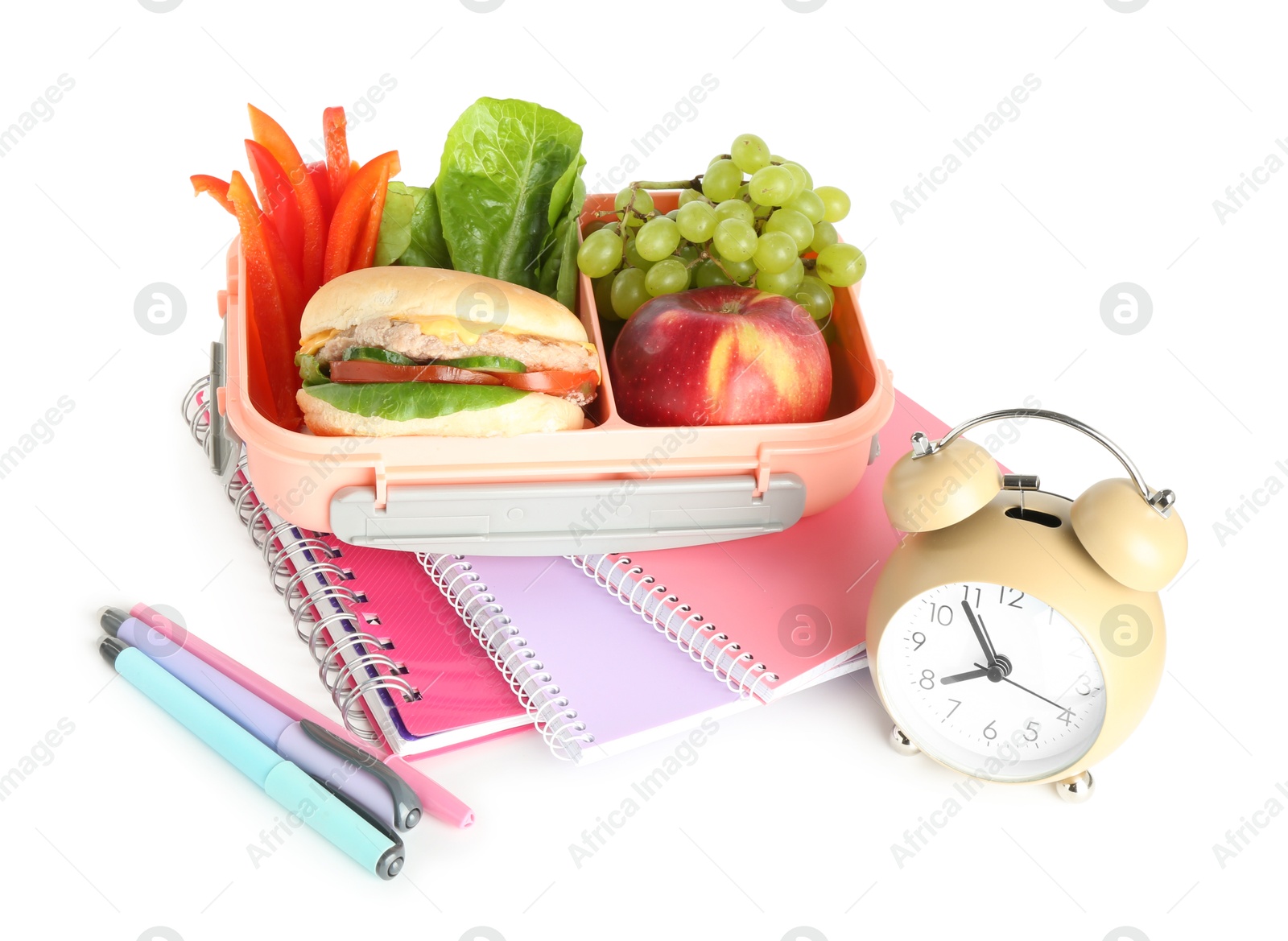 Photo of Lunch box with snacks, stationery and alarm clock isolated on white