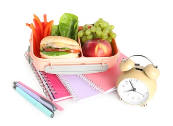 Photo of Lunch box with snacks, stationery and alarm clock isolated on white