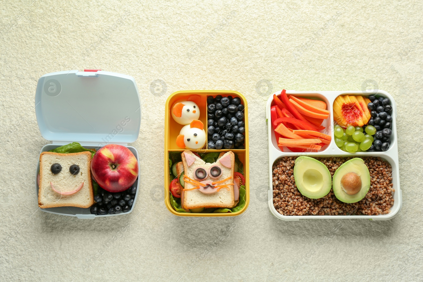 Photo of Lunch boxes with different snacks on beige textured table, flat lay