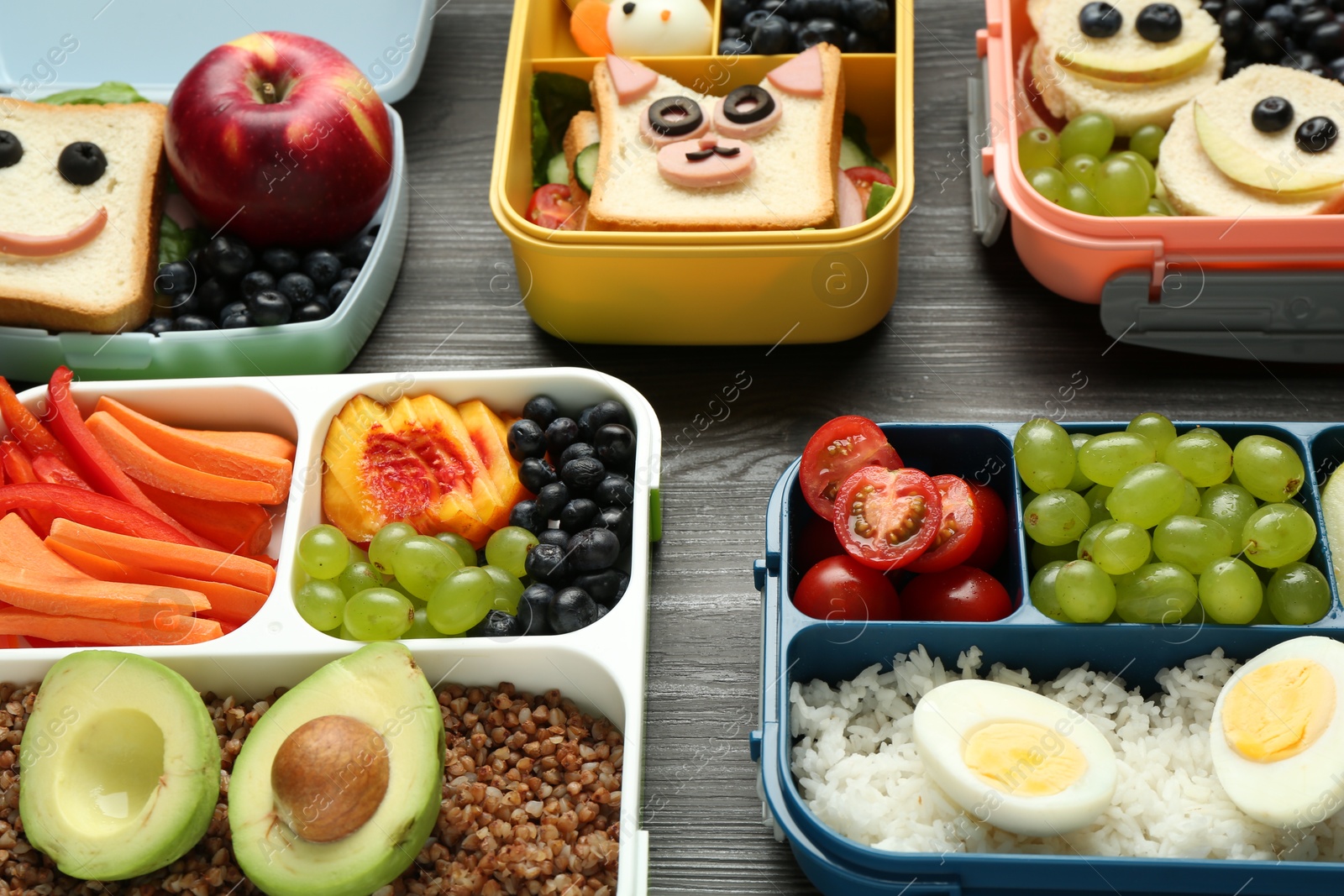 Photo of Lunch boxes with different snacks on wooden table, closeup