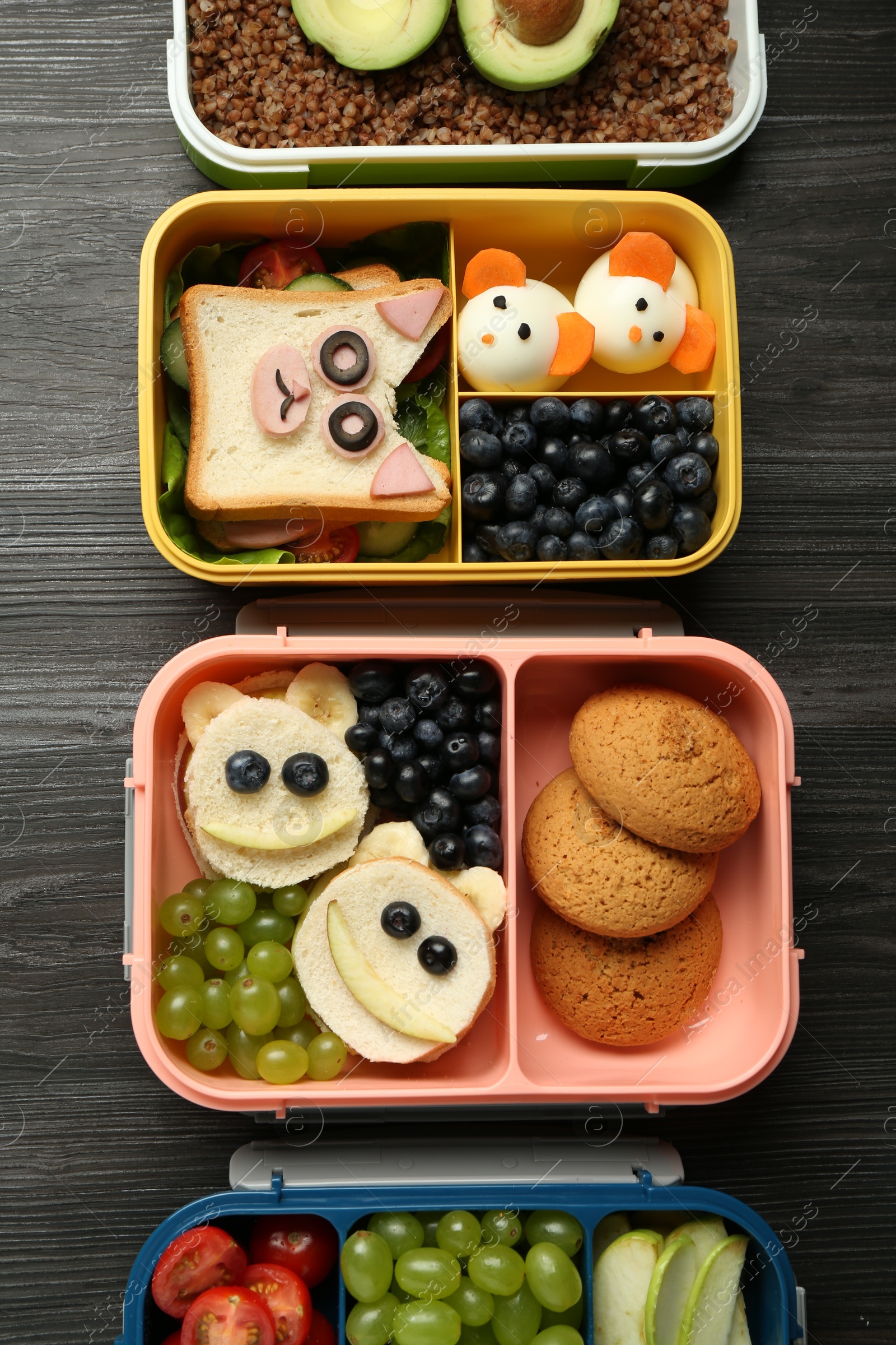 Photo of Lunch boxes with different snacks on wooden table, flat lay