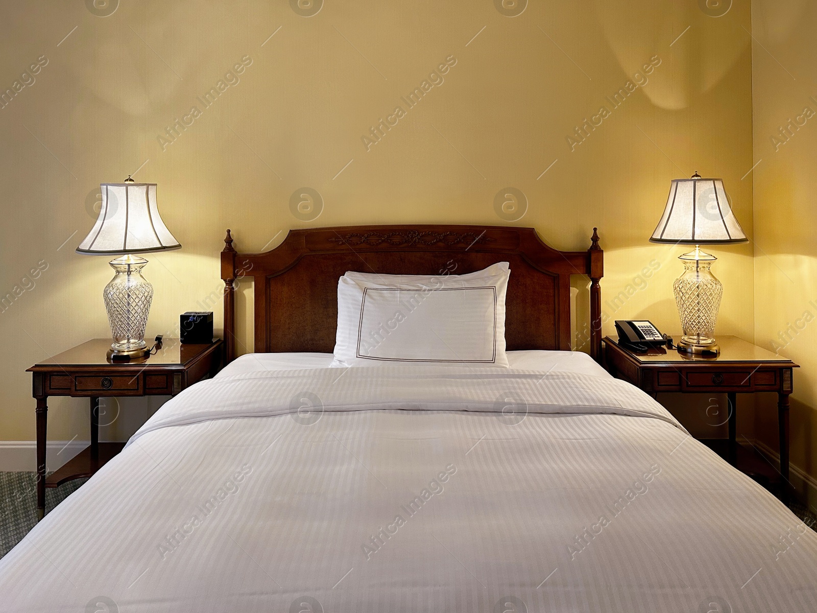 Photo of Comfortable large bed and modern furniture in stylish hotel room