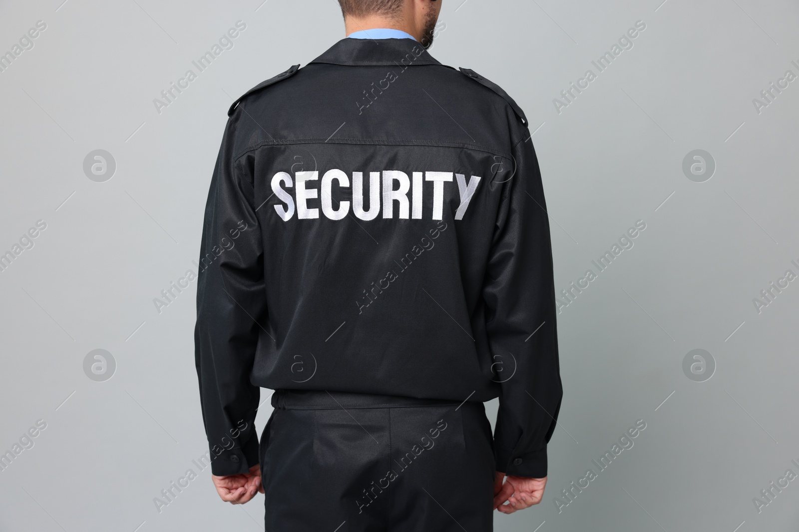 Photo of Security guard in uniform on grey background, closeup