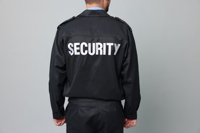 Security guard in uniform on grey background, closeup