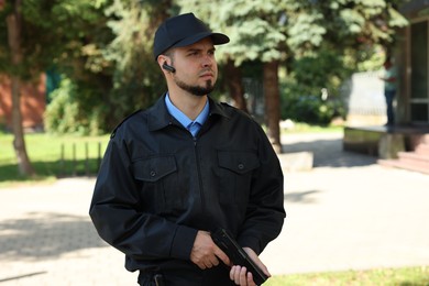 Security guard in uniform with gun outdoors