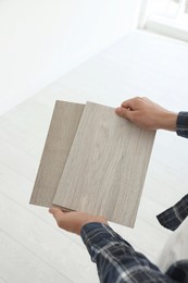 Photo of Man with samples of wooden flooring indoors, closeup