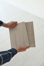 Photo of Man with samples of wooden flooring indoors, closeup