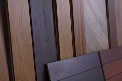 Photo of Many different samples of wooden flooring as background, closeup