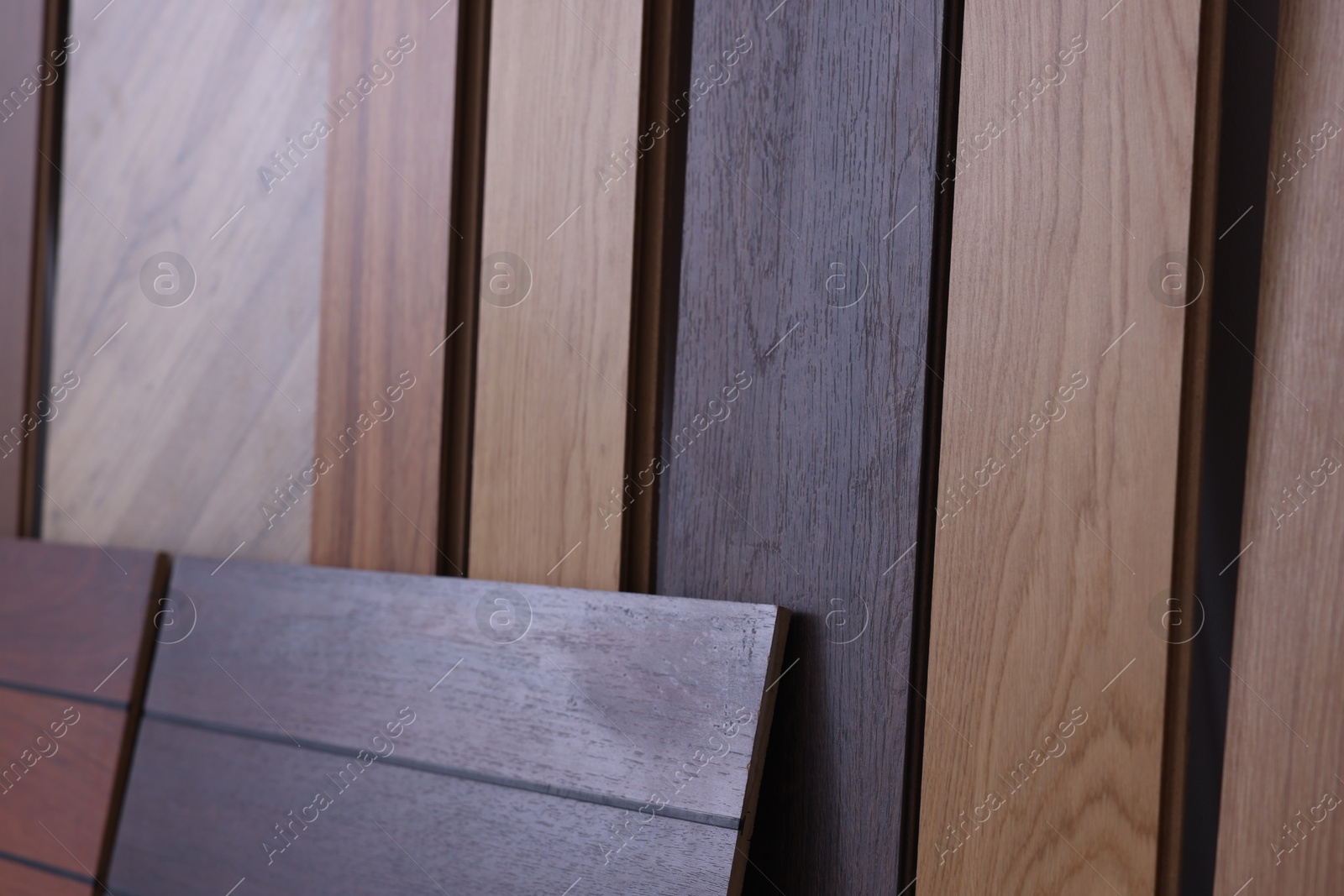 Photo of Many different samples of wooden flooring as background, closeup