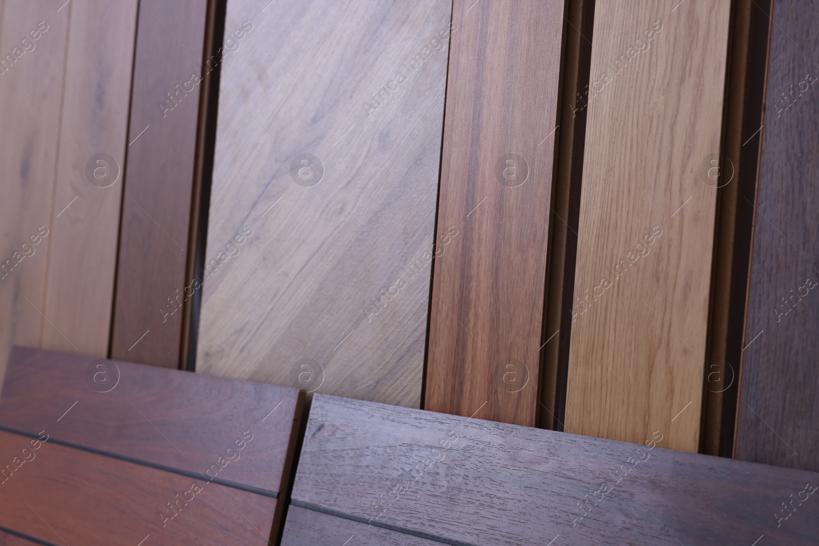 Photo of Many different samples of wooden flooring as background, closeup